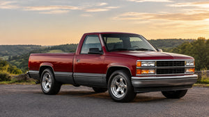 Close-up of an OBS badge mounted on a glossy red truck tailgate